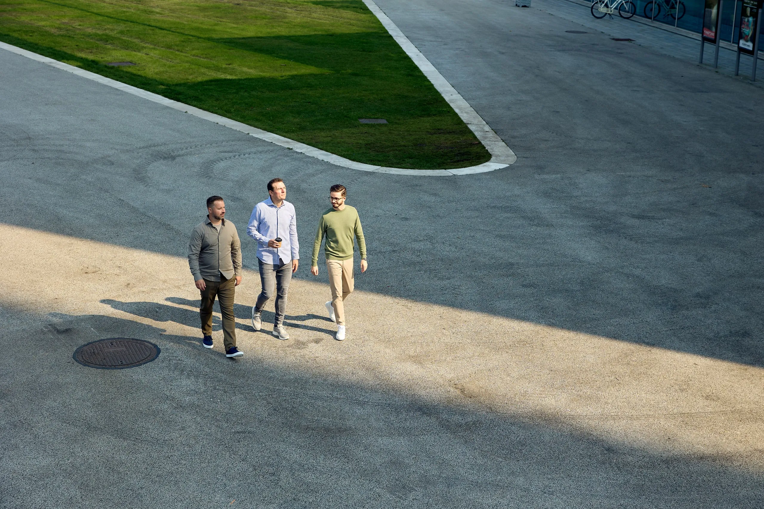 Drie medewerkers lopen over een plein