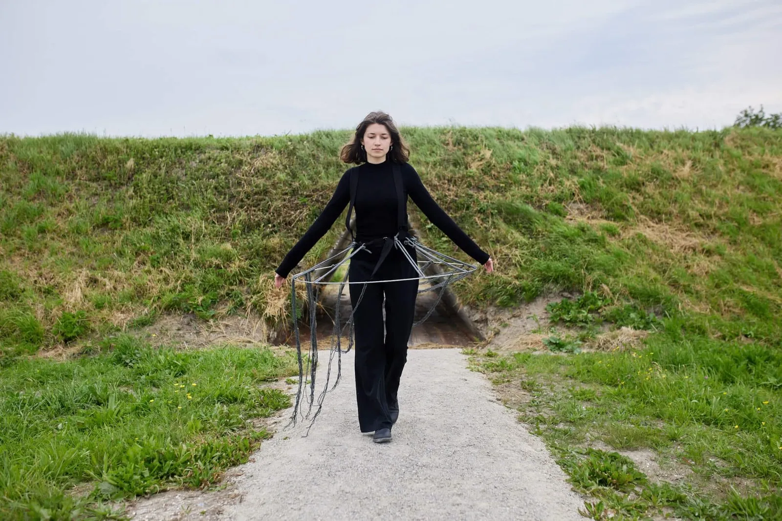 Vrouw in het zwart op een pad over de dijk