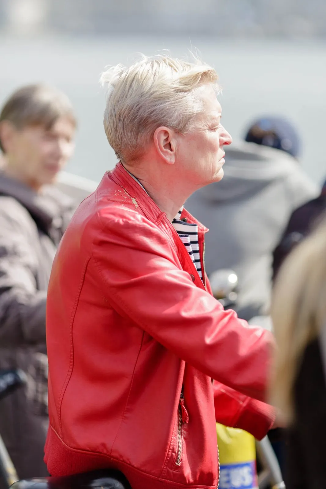 Vrouw met rode jas bij de pont over het IJ